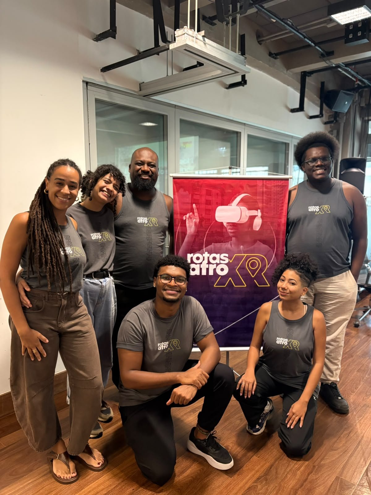 Grupo reunido diante do banner Rotas Afro XR