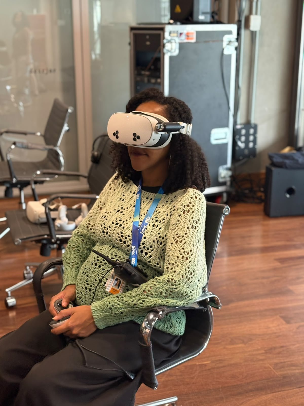 Participante com roupa verde usando óculos de realidade virtual
